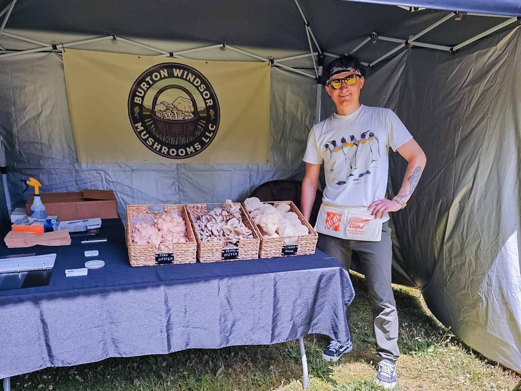 Paul from Burton Windsor Mushrooms at the farmers market with a table of fresh gourmet mushrooms